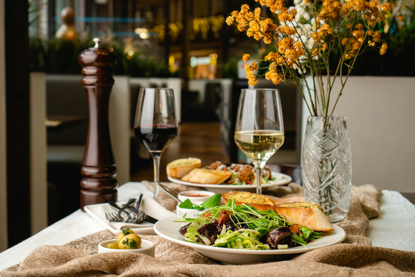 A restaurant table set with wine and appetizers