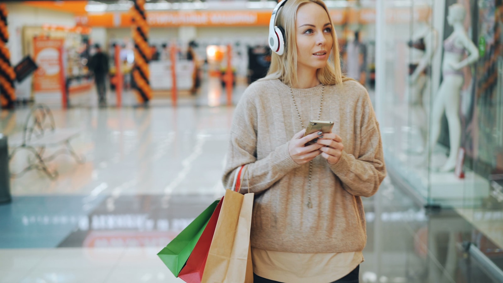 A shopper with bags walking through a mall